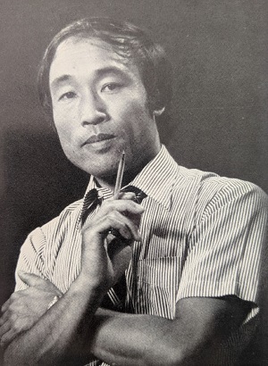 ボールペンを片手にポーズを取る田口明さん。この写真は日豪プレスの田口さんの記事にも掲載されていた(写真提供:クミ・タグチさん)