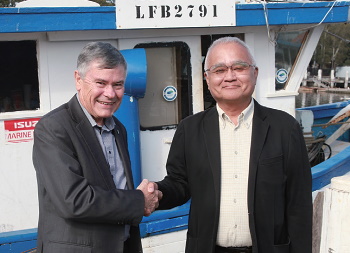 握手を交わす元築地市場場長の森本博行氏(右)とシドニー・フィッシュ・マーケット・ゼネラル・マネジャーのブライアン・スケッパー氏
