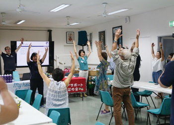 ココナッツ体操というアクティビティで体を動かす参加者(Photo: Taka Uematsu)