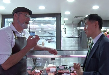 岐阜県から来た職員に説明する食肉販売店オーナー、ギャリー･マクビーンさん（メルボルン郊外18年12月筆者撮影）