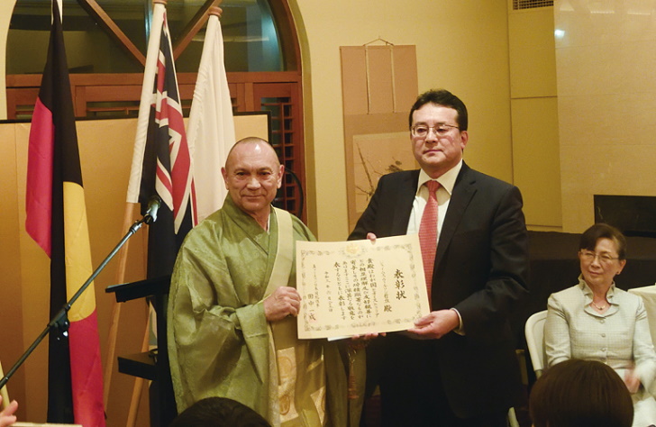表彰状を受け取るウィルソン哲雄氏（左）写真提供：在ブリスベン日本国総領事館