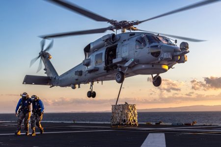 Two Royal Australian Navy flight deck operators move away from a MH-60R Seahawk helicopter during a training scenario aboard HMAS Adelaide.  *** Local Caption *** Royal Australian Navy Landing Helicopter Dock HMAS Adelaide conducted staff-led continuation training, including damage control drills, boarding exercises, heightened state messing, mass casualty exercises and flight deck operations from 08 - 22 April.